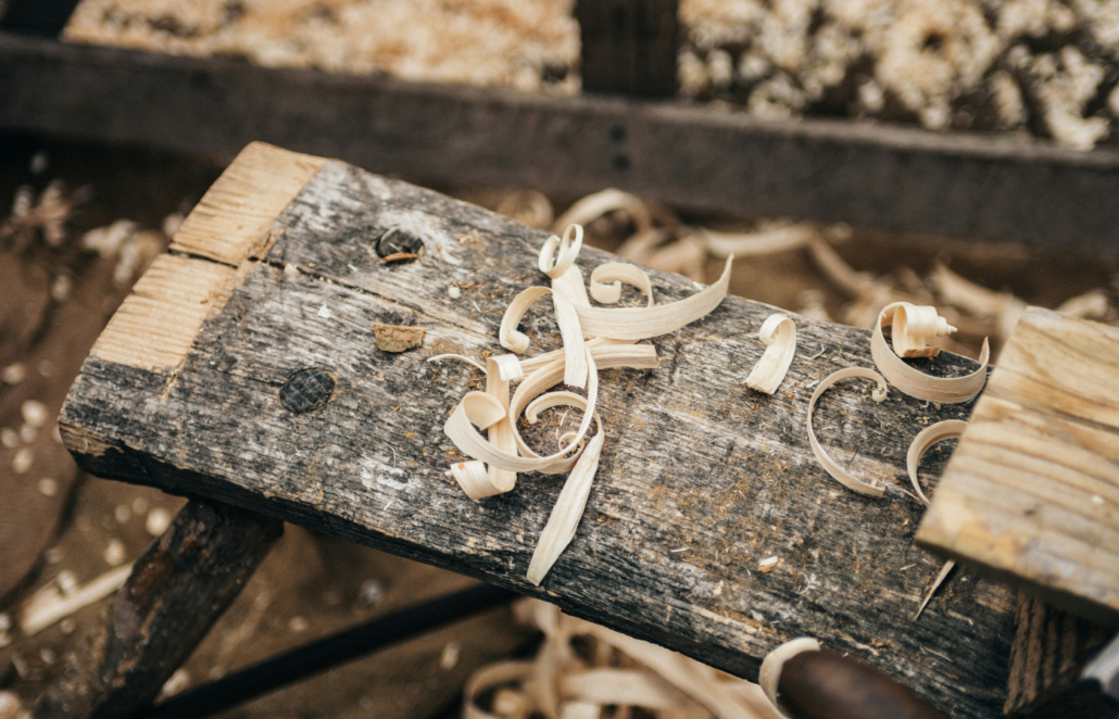 Piece of carved wood on a pile of wood.