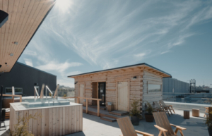 A sauna cabin and a cold plunge pool on a rooftop.